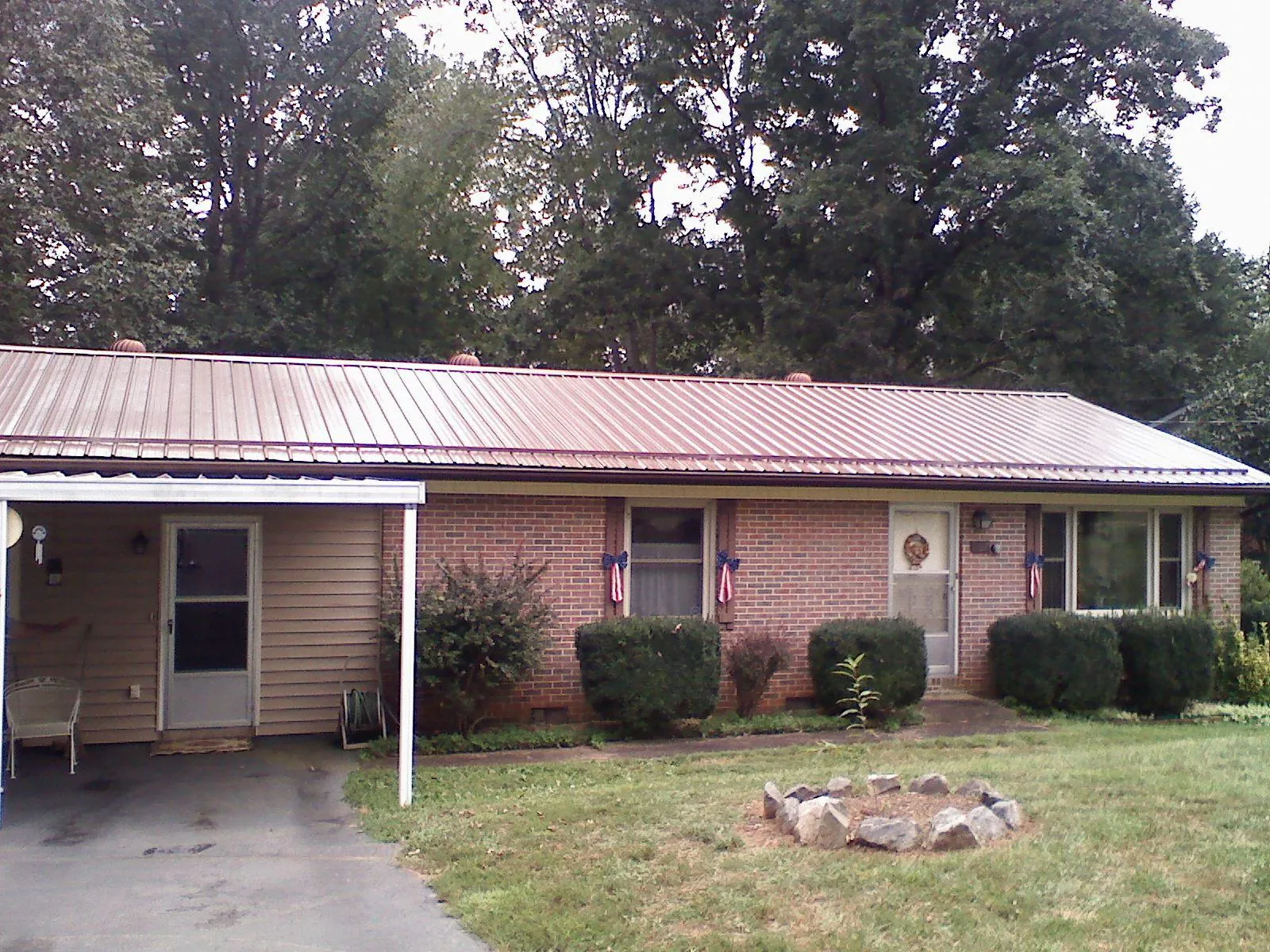 Bronze metal roof and carport on a brick ranch home — Roof Repair work by our crew in Clovis