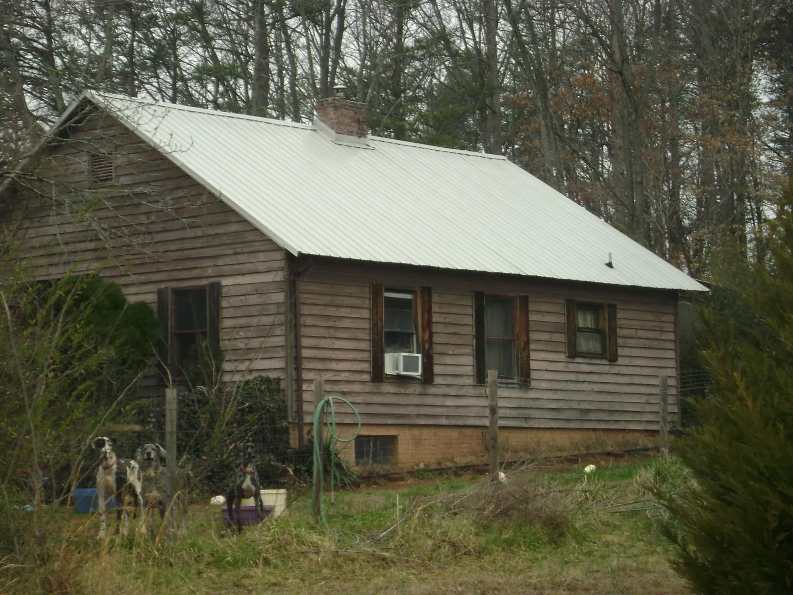 White metal roof on an old wood sided farmhouse, from a Metal Roof Installation job in Clovis